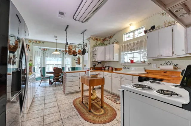 a kitchen with a sink a stove and chairs
