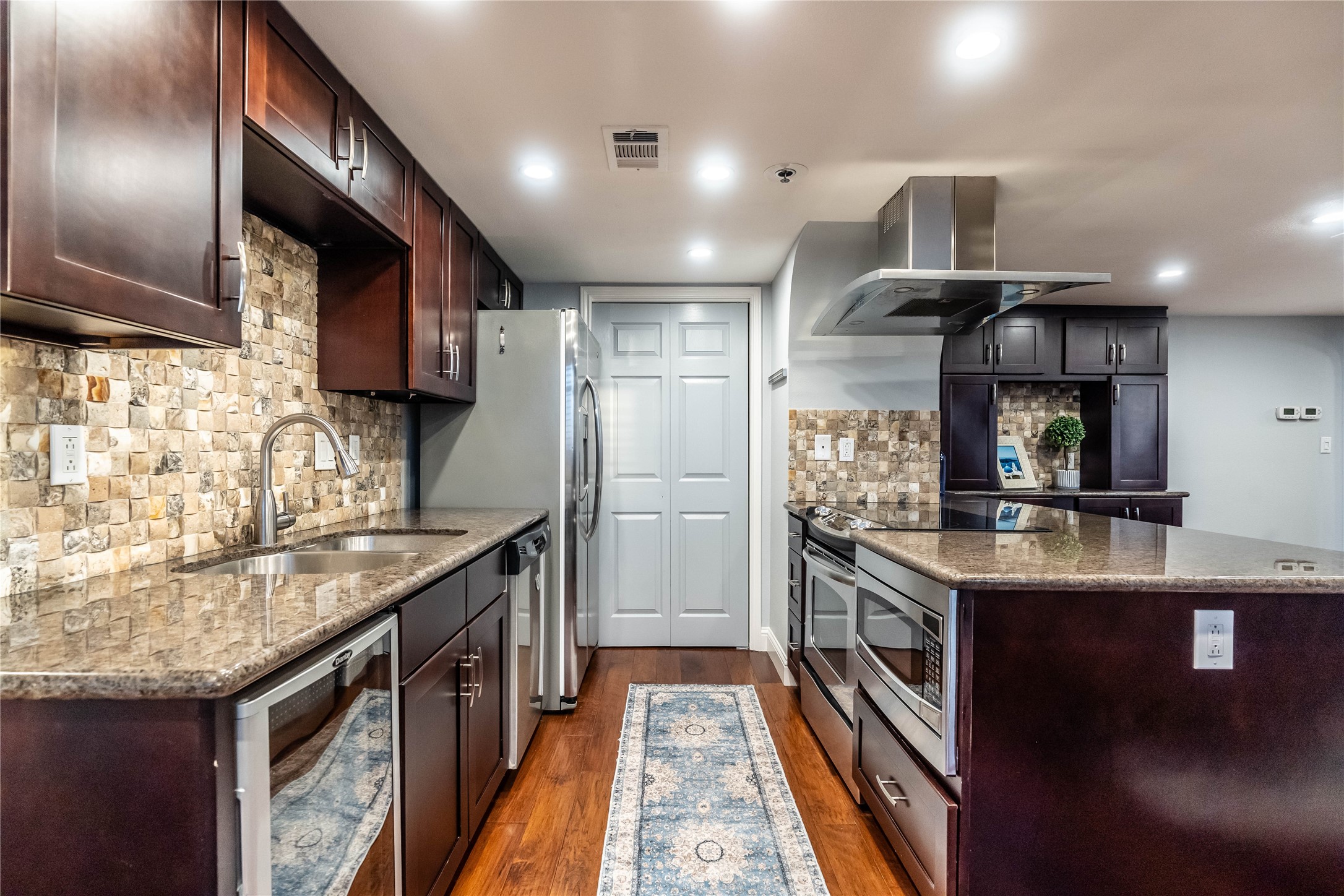 3525 Sage Road, Unit 1511 Houston, TX 77056 - Photo 7 of 25 a kitchen with kitchen island granite countertop a sink stove and refrigerator