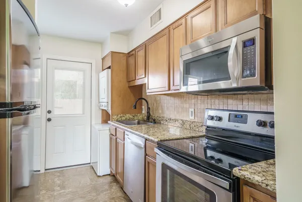 a kitchen with stainless steel appliances granite countertop a stove microwave and cabinets
