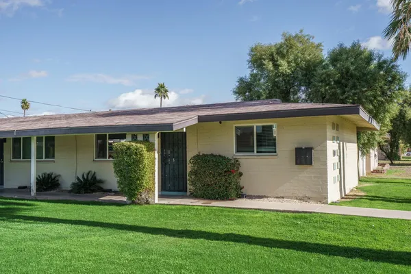 a front view of a house with a garden and plants