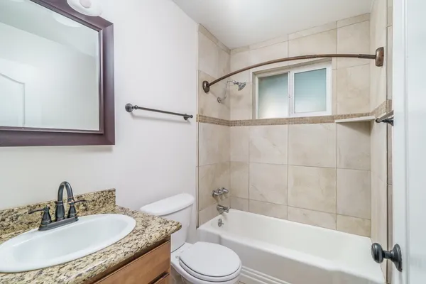 a bathroom with a granite countertop sink toilet and shower