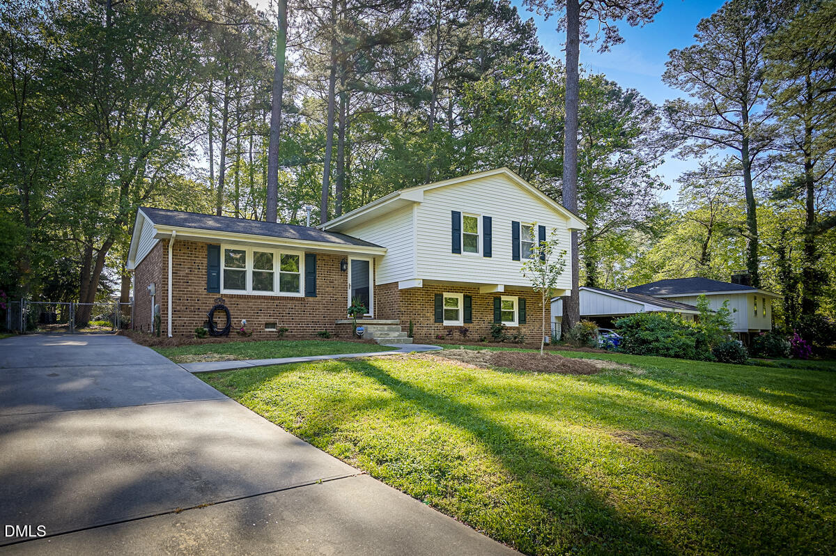 a front view of a house with a yard and trees