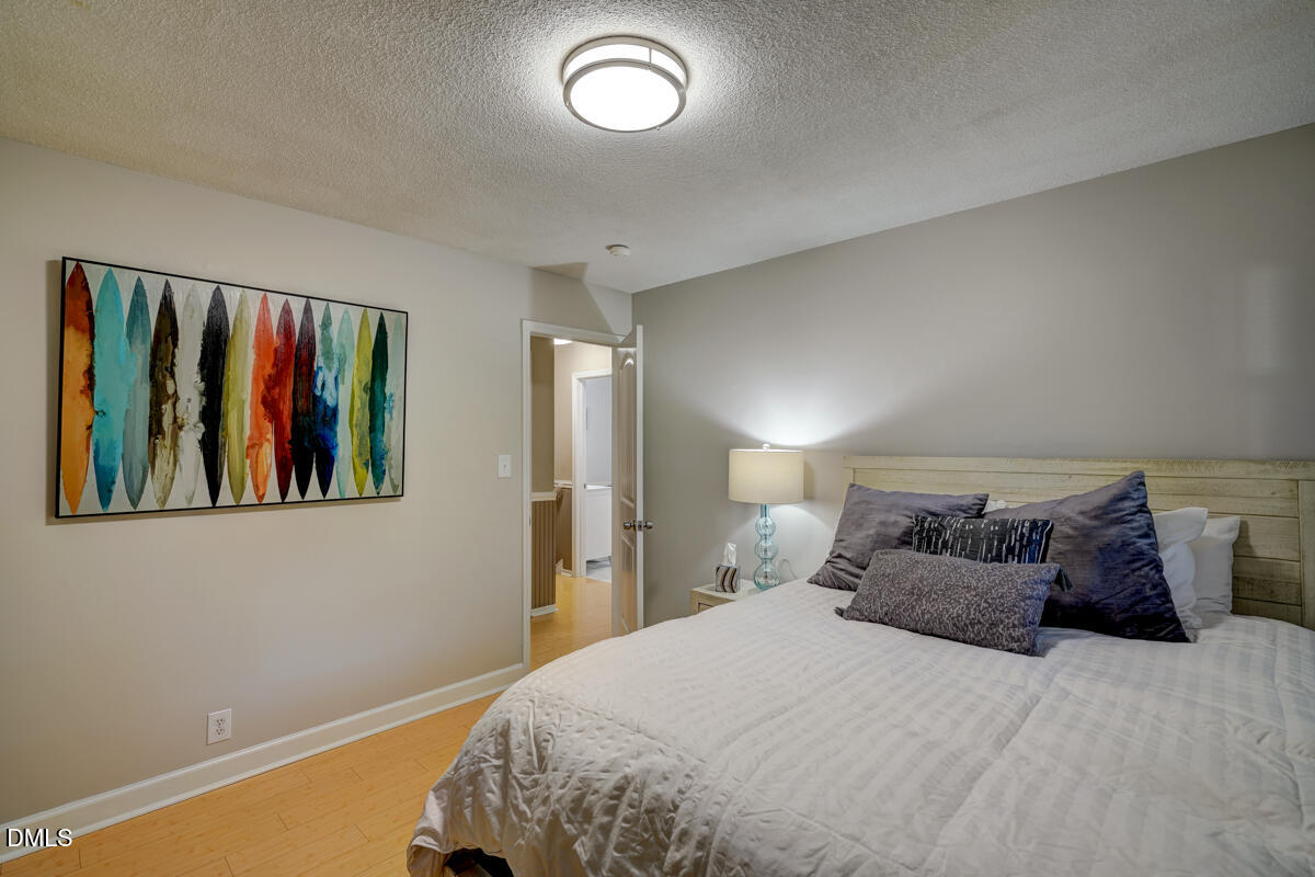 3418 Huntleigh Drive Raleigh, NC 27604 - Photo 45 of 55 a bedroom with a large bed and a painting on the wall
