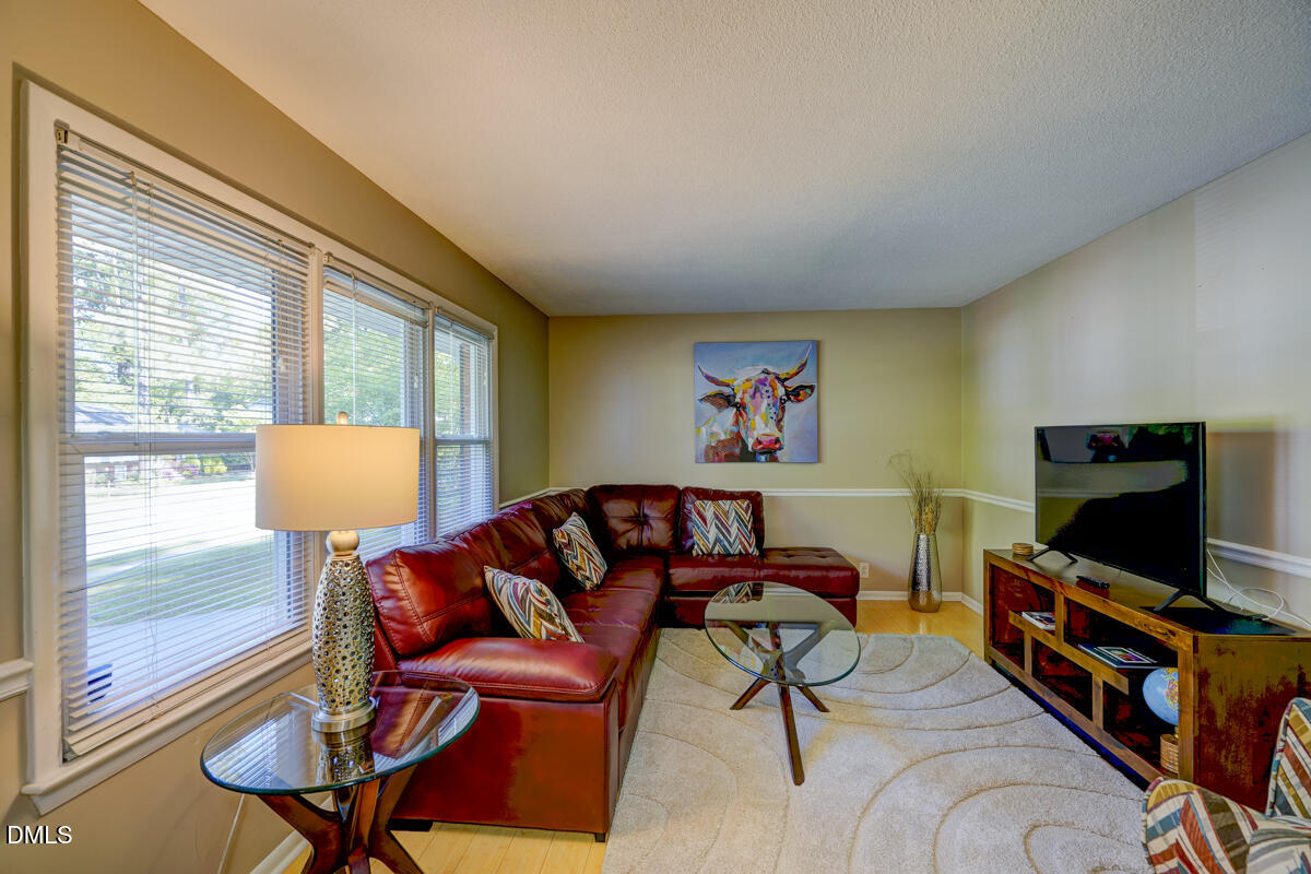 3418 Huntleigh Drive Raleigh, NC 27604 - Photo 6 of 55 a living room with furniture and a flat screen tv