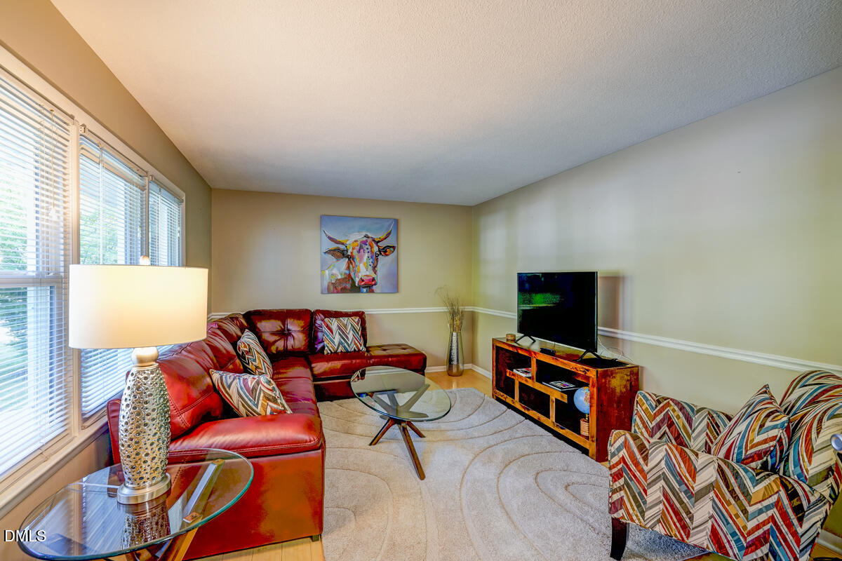 3418 Huntleigh Drive Raleigh, NC 27604 - Photo 7 of 55 a living room with furniture a flat screen tv and a window