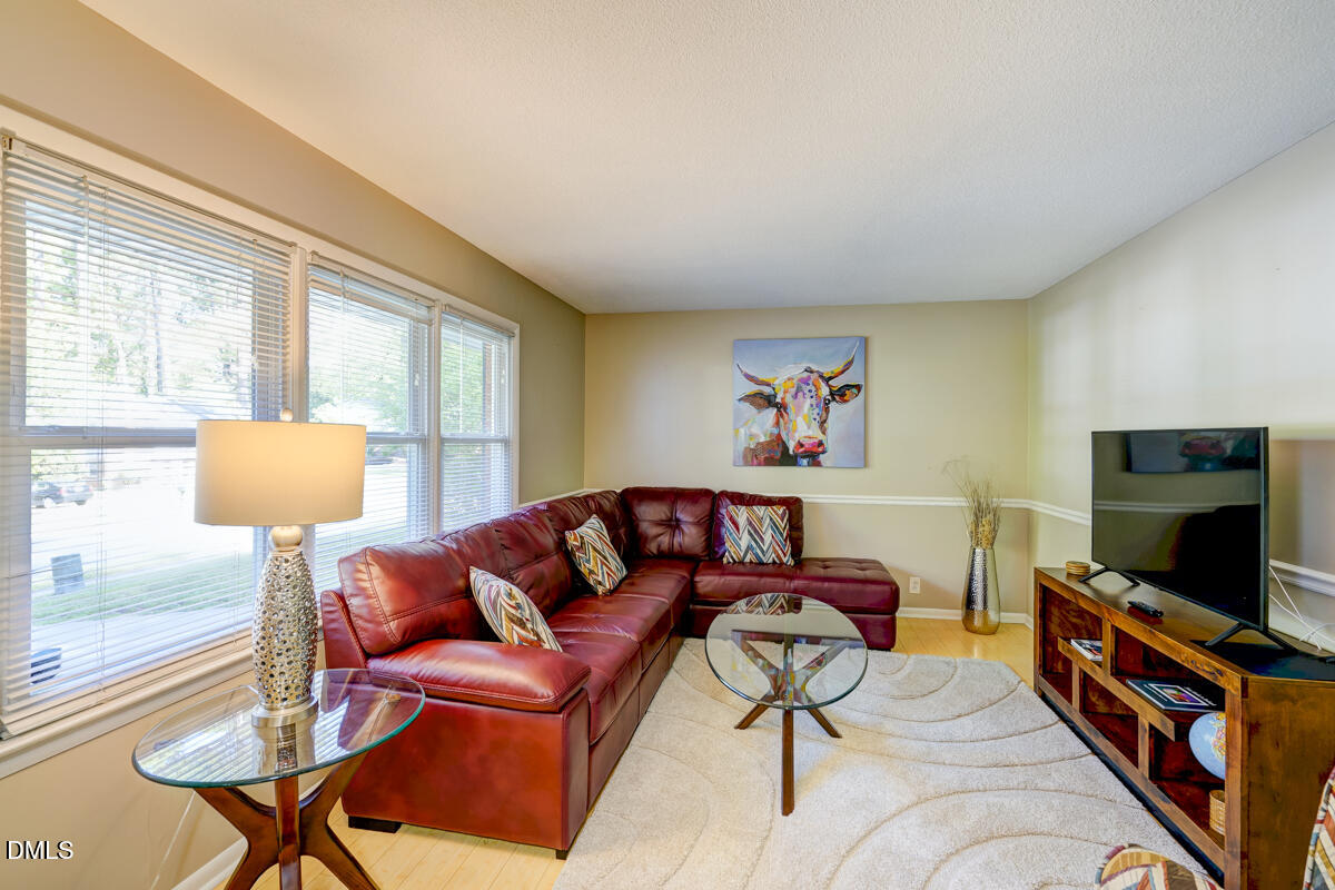 3418 Huntleigh Drive Raleigh, NC 27604 - Photo 8 of 55 a living room with furniture and a flat screen tv
