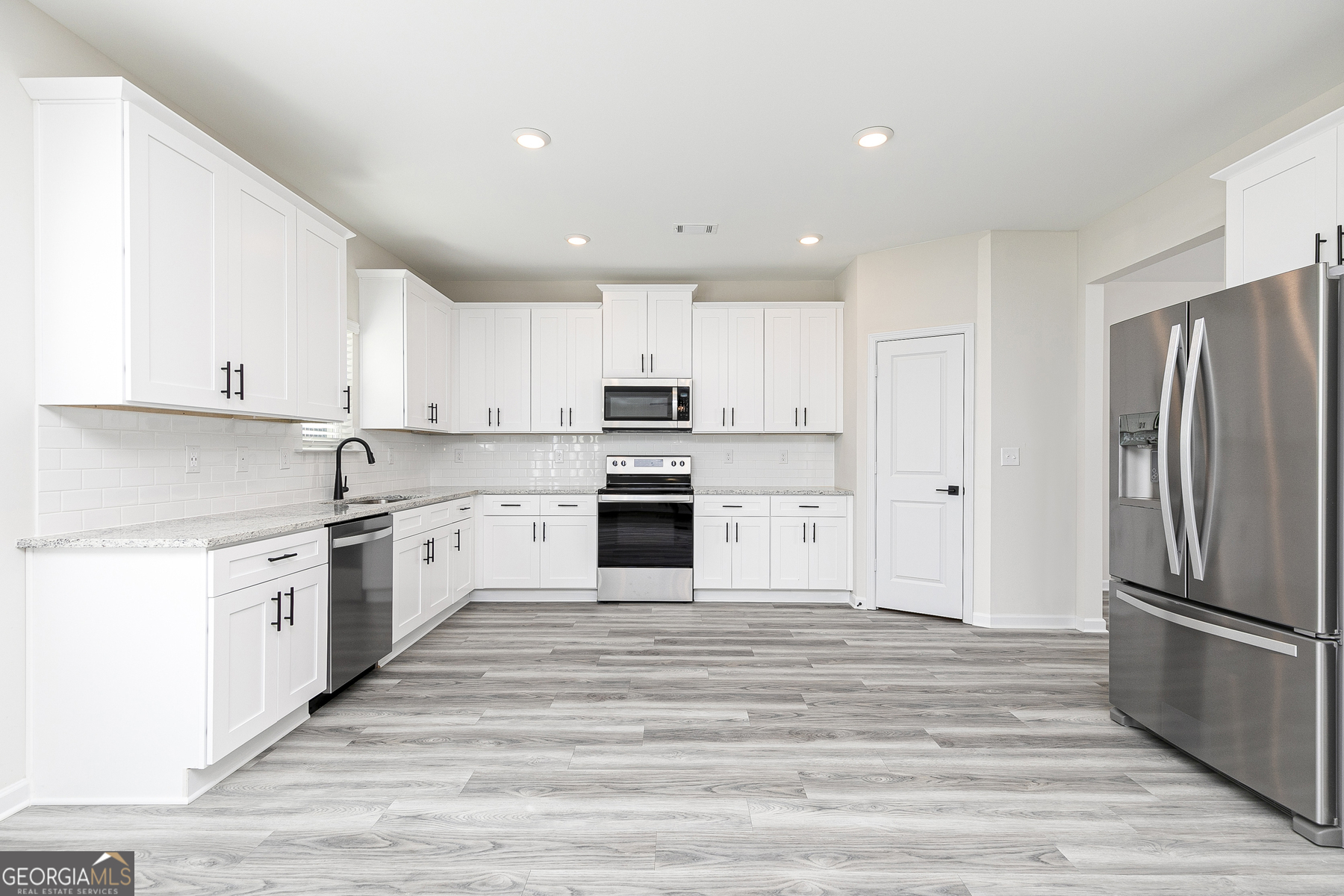 161 Sunfish Circle Hoschton, GA 30548 - Photo 6 of 13 a large kitchen with cabinets stainless steel appliances and a window