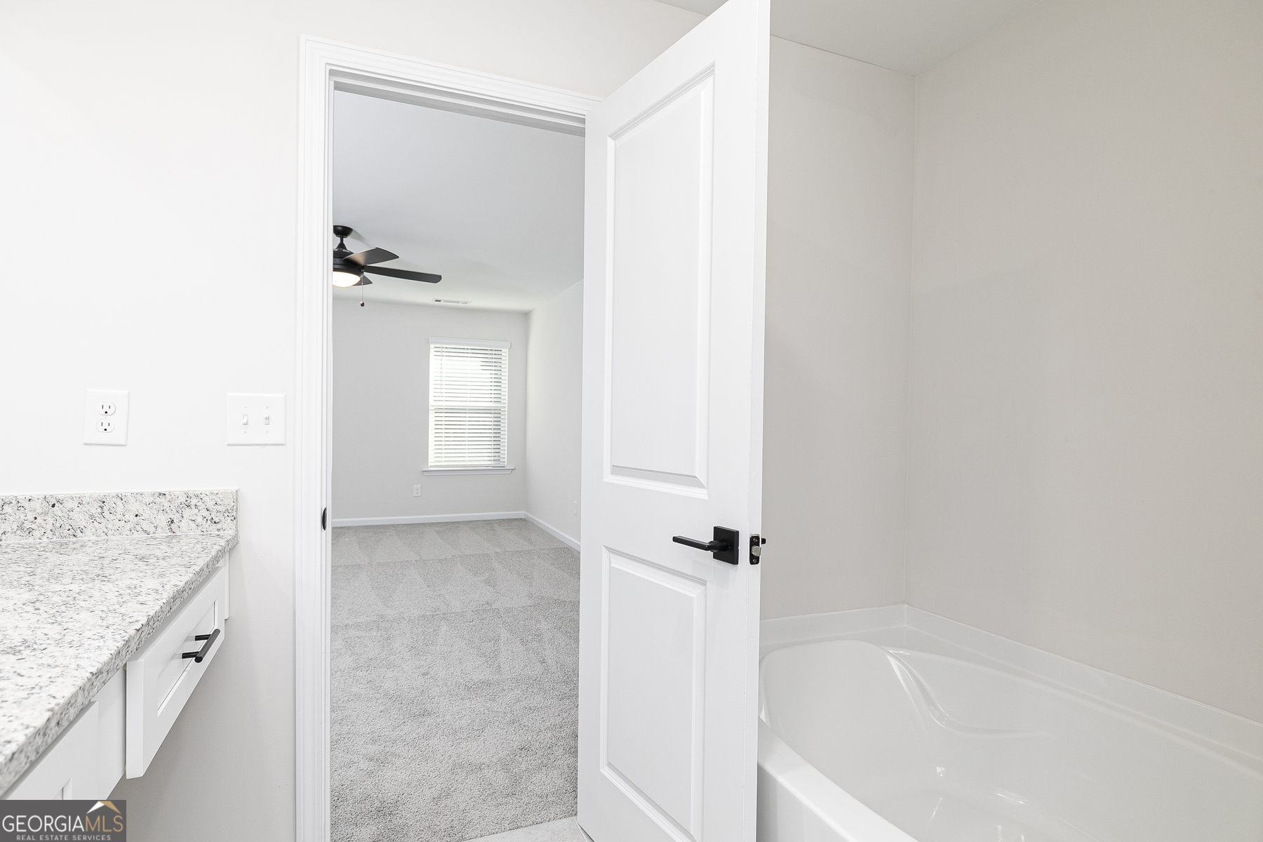161 Sunfish Circle Hoschton, GA 30548 - Photo 9 of 13 a spacious bathroom with a granite countertop sink and mirror with bathtub
