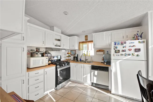 a kitchen with white cabinets and white appliances