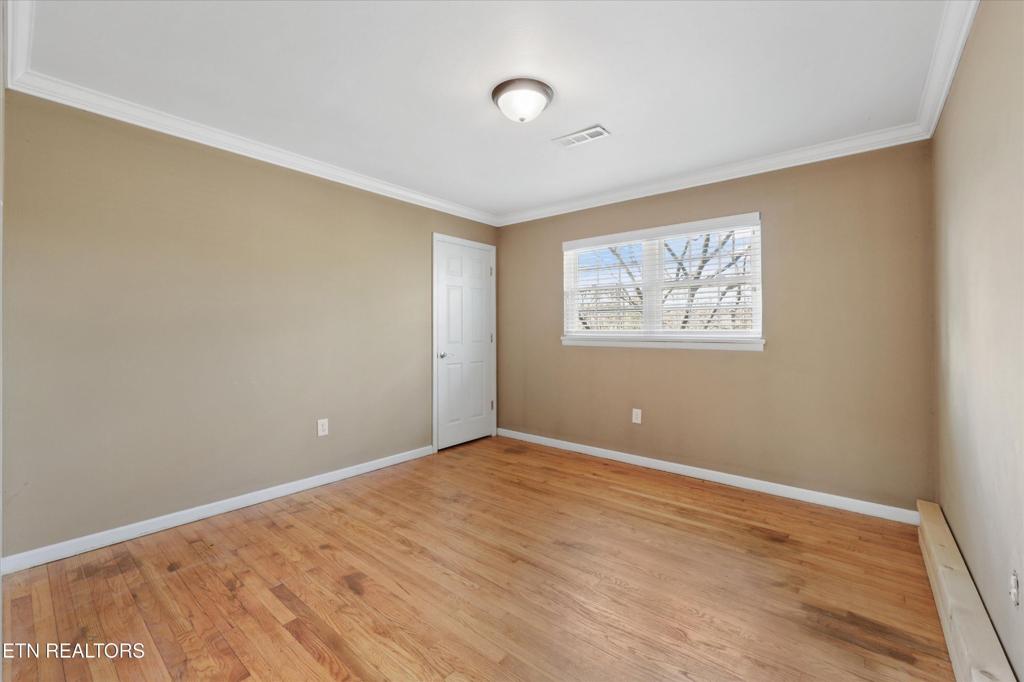 1221 Huntington Road Southwest Knoxville, TN 37919 - Photo 15 of 23 a view of an empty room with wooden floor and a window