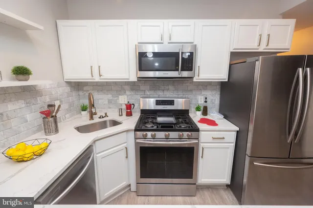 a kitchen with appliances a sink and a stove