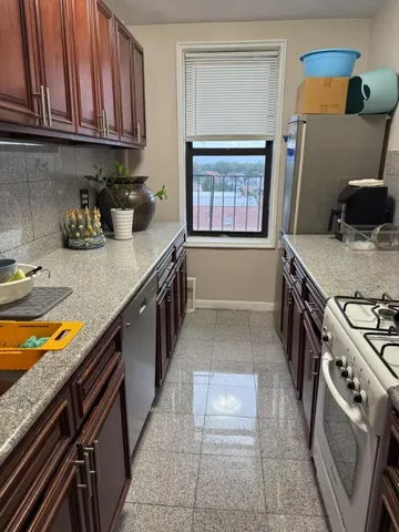 a kitchen with stainless steel appliances granite countertop a stove a sink and a microwave