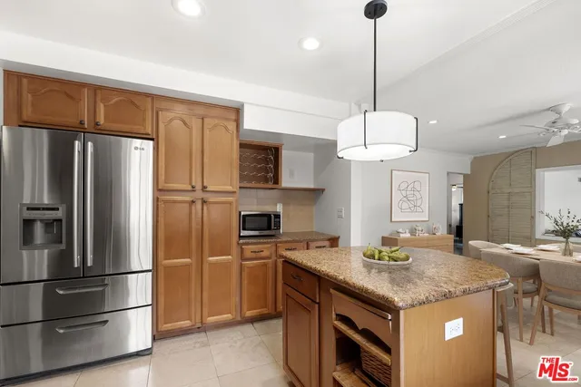 a kitchen with stainless steel appliances granite countertop a refrigerator a sink and a stove