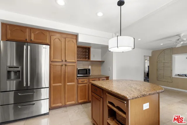 a kitchen with stainless steel appliances granite countertop a refrigerator a stove and a sink