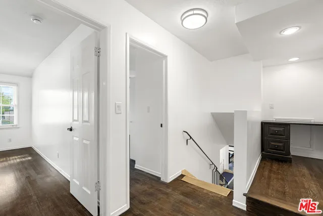 a view of a hallway with bathroom and wooden floor