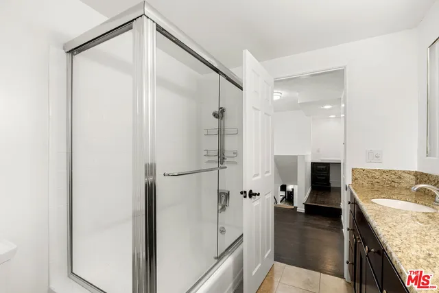 a bathroom with a granite countertop sink mirror bathtub and shower