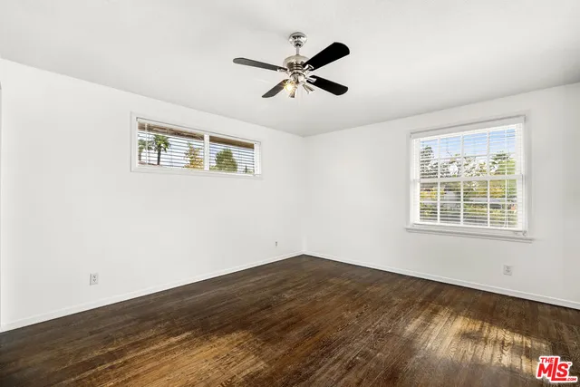 a view of a room with wooden floor and ceiling fan