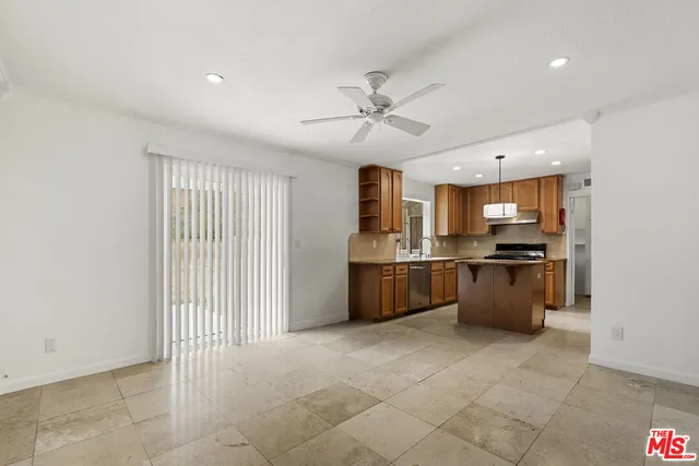 a large kitchen with a large counter top stainless steel appliances and cabinets