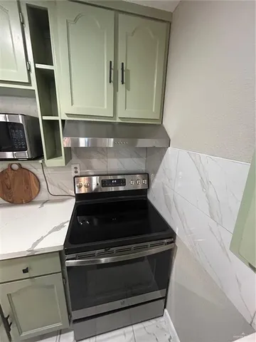 a stove top oven sitting inside of a kitchen