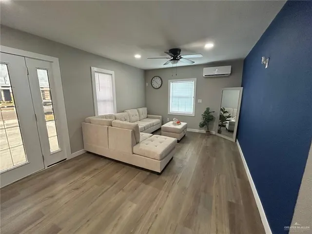 a living room with furniture and a wooden floor
