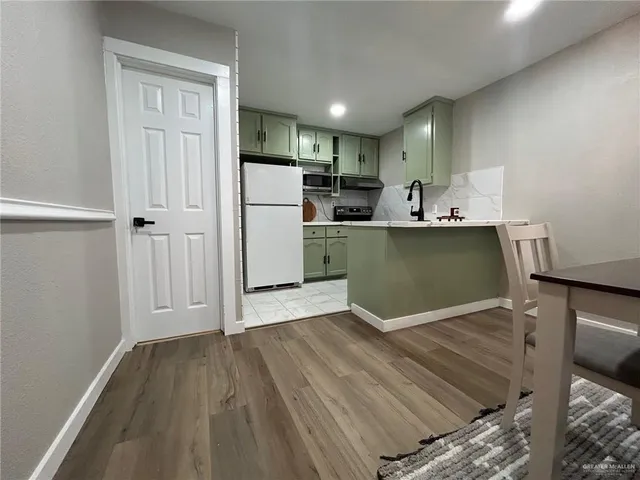 a kitchen with a refrigerator and a stove top oven