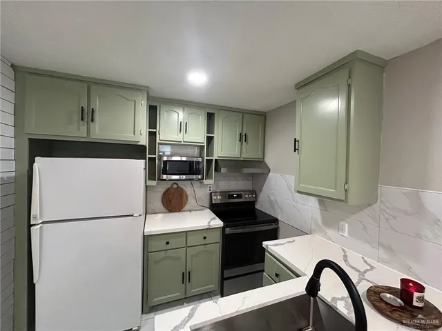 a kitchen with a refrigerator and a stove top oven