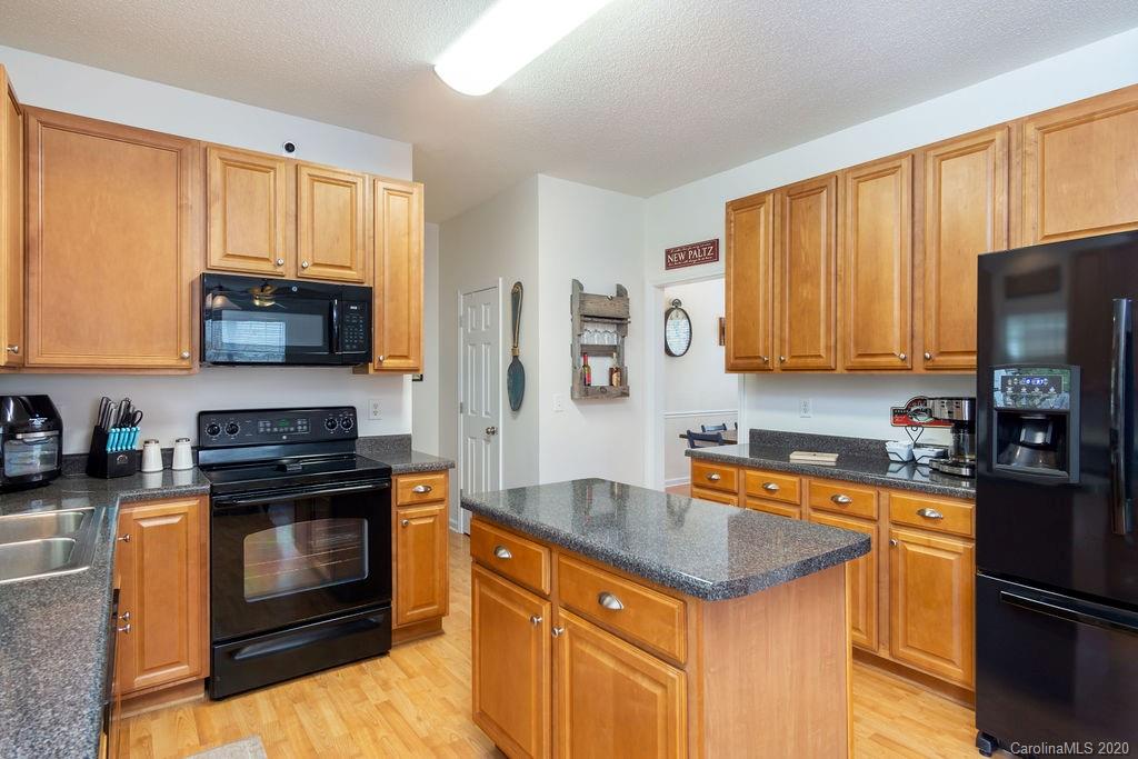 94 Wildbriar Road Fletcher, NC 28732 - Photo 4 of 27 a kitchen with granite countertop a stove top oven microwave and refrigerator