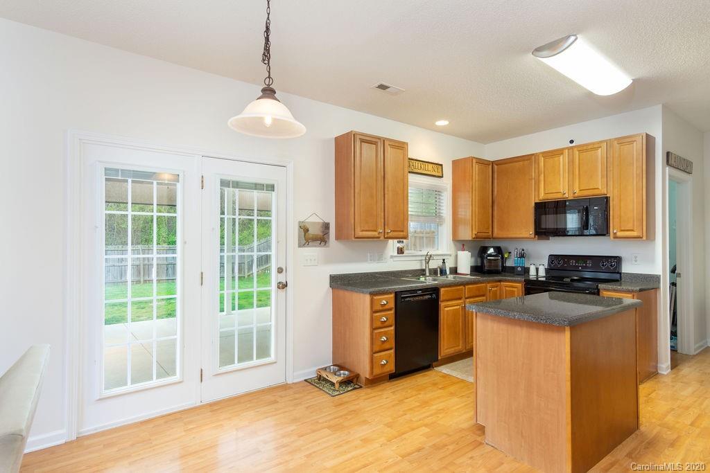 94 Wildbriar Road Fletcher, NC 28732 - Photo 7 of 27 a kitchen with stainless steel appliances granite countertop a stove top oven a sink dishwasher a refrigerator and a dining table with wooden floor