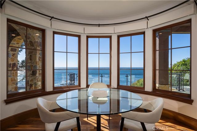 a view of a dining room with furniture large windows and wooden floor