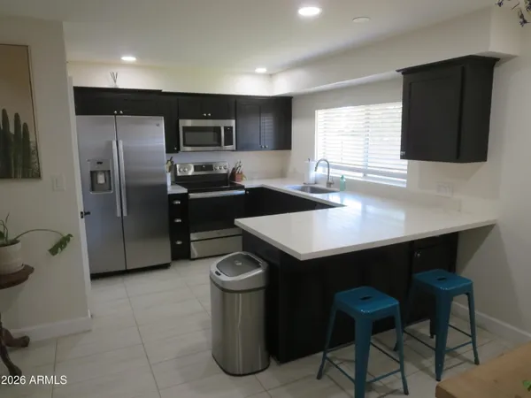 a kitchen with stainless steel appliances a refrigerator a sink a stove a microwave and island
