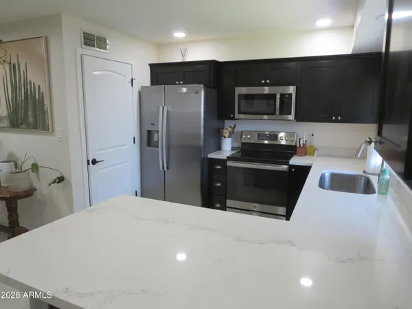 a view of a workspace with furniture and a window