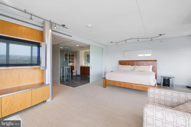 a bedroom with a bed and a potted plant