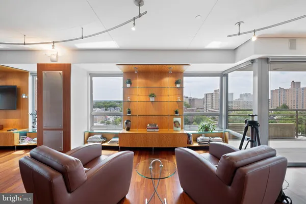 a very nice looking living room with a large window and dining table