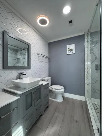 a bathroom with a toilet sink and mirror