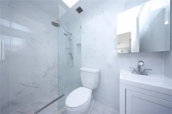 a white toilet sitting next to a bathroom sink
