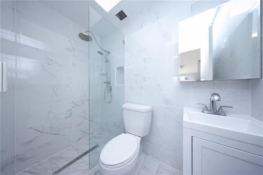 316 101st Street, Unit 41E Brooklyn, NY 11209 - Photo 11 of 26 a white toilet sitting next to a bathroom sink