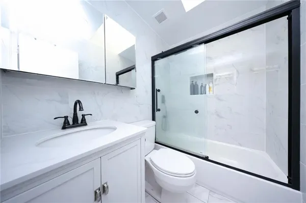 a bathroom with a sink a toilet and shower