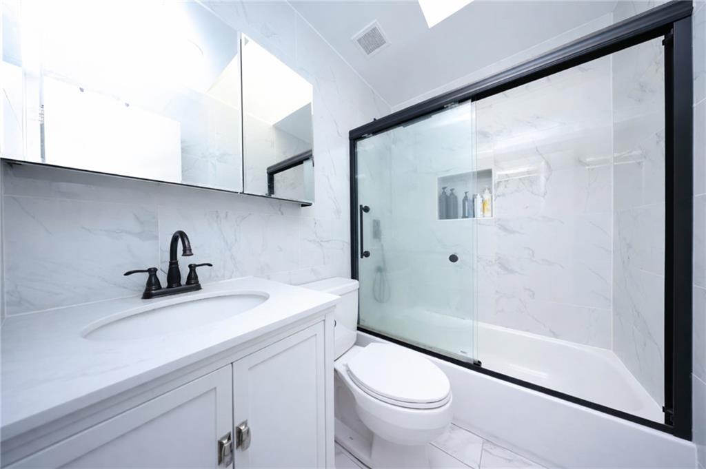316 101st Street, Unit 41E Brooklyn, NY 11209 - Photo 14 of 26 a bathroom with a sink a toilet and shower