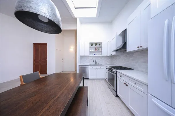 a kitchen with stainless steel appliances granite countertop a stove a sink and a microwave