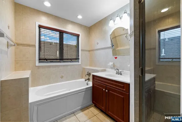 a bathroom with a tub sink and mirror