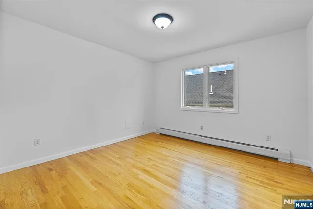 an empty room with a wooden floor and windows
