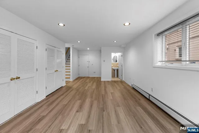 a view of empty room with wooden floor