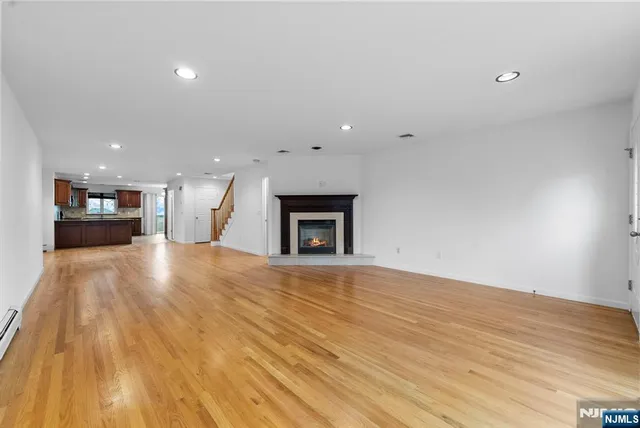 a view of empty room with wooden floor and fireplace