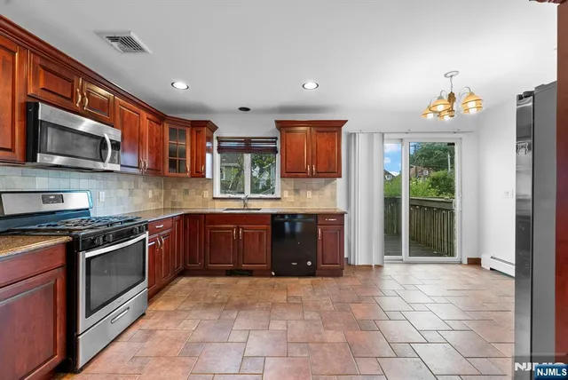 a kitchen with stainless steel appliances granite countertop a refrigerator and a stove top oven