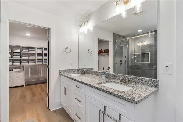 a bathroom with a granite countertop sink a large mirror and shower