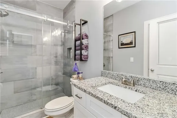 a bathroom with a sink a toilet and shower