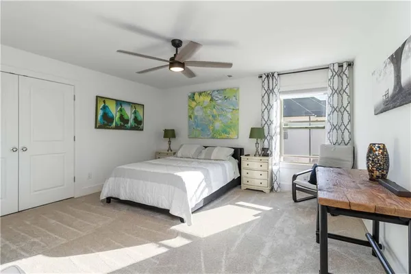 a spacious bedroom with a bed a table and large window