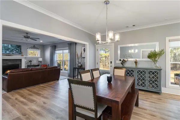 a living room with furniture a dining table and a chandelier