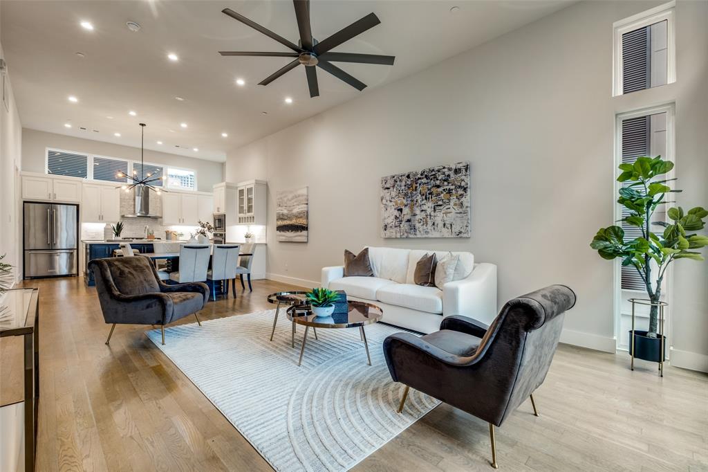 a living room with furniture kitchen view and a potted plant