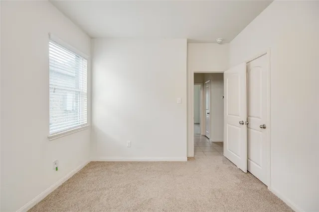 an empty room with windows and closet